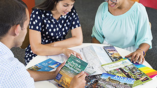 Group sitting at table with travel brochures