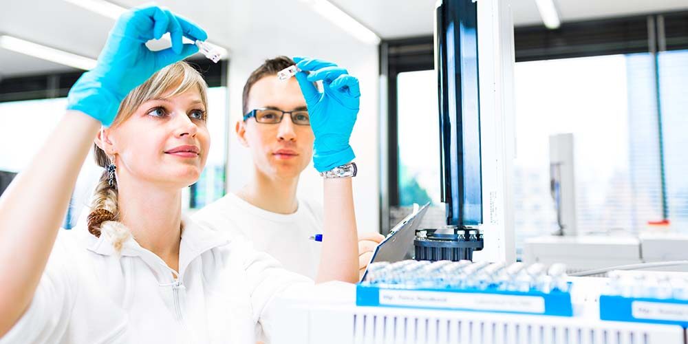 Two young researchers carrying out experiments in a lab