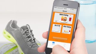 person holding a mobile phone with LiveLighter App with running shoes in the background