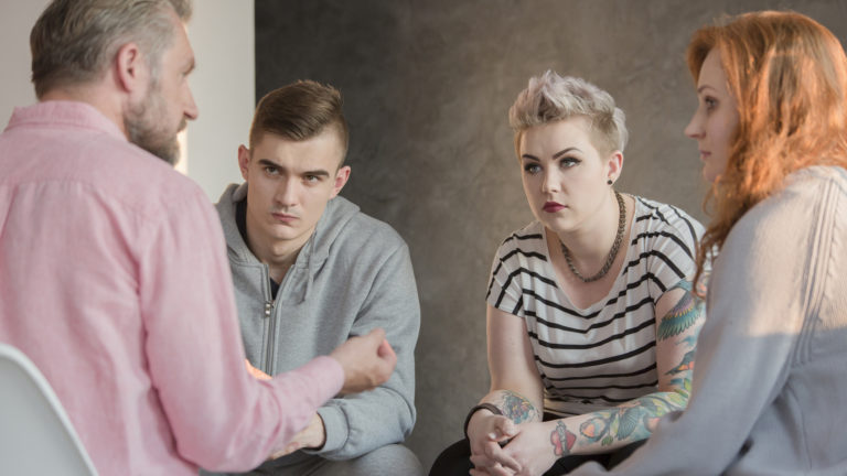Psychologist talking with group of problematic teenagers