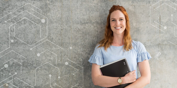 Female Curtin University researcher standing against a grey wall
