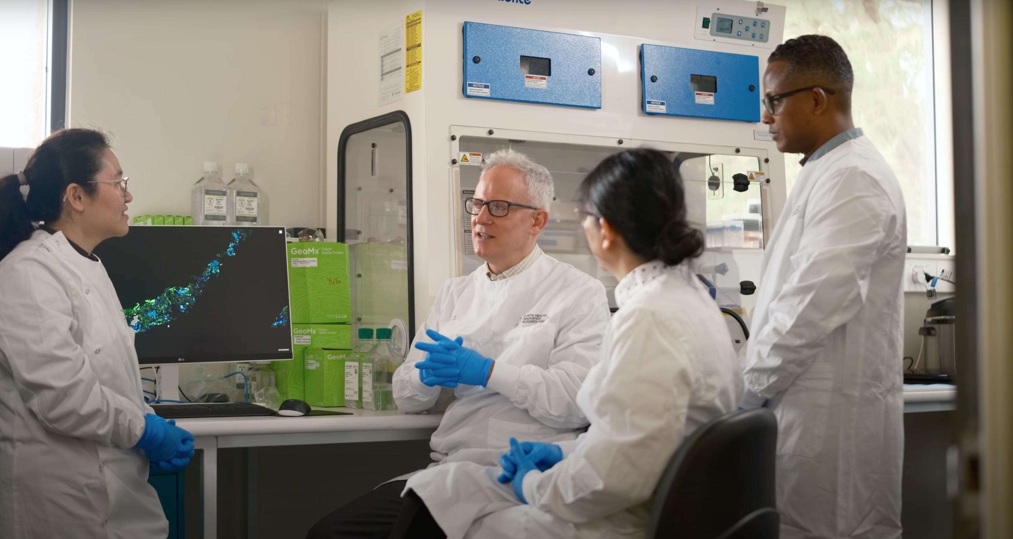 Research team in lab coats in discussion