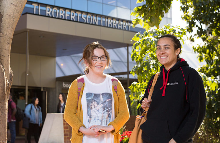 Two students in front of the Curtin library